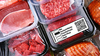 Verschiedene verpackte Fleischprodukte, davor beispielhaft das neue staatliche Tierhaltungskennzeichen
