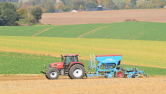 Traktor auf dem Feld bei der Winterweizensaat.