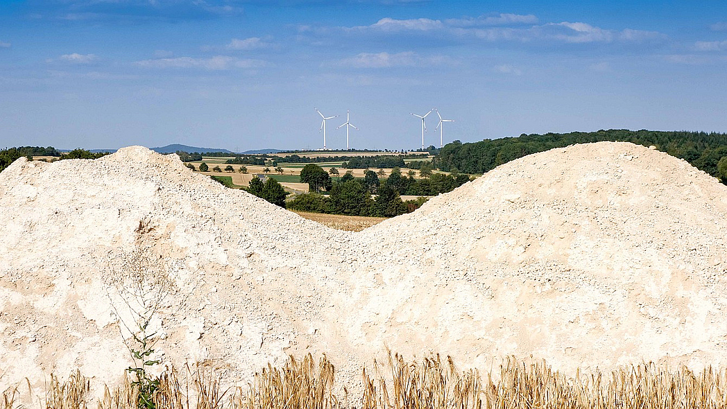 Haufen Carbokalk als Nebenprodukt der Zuckerproduktion auf landwirtschaftlicher Fläche.