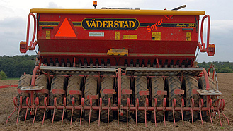 Rückansicht eines Treckers mit Drillmaschine bei der Wintergetreideaussaat