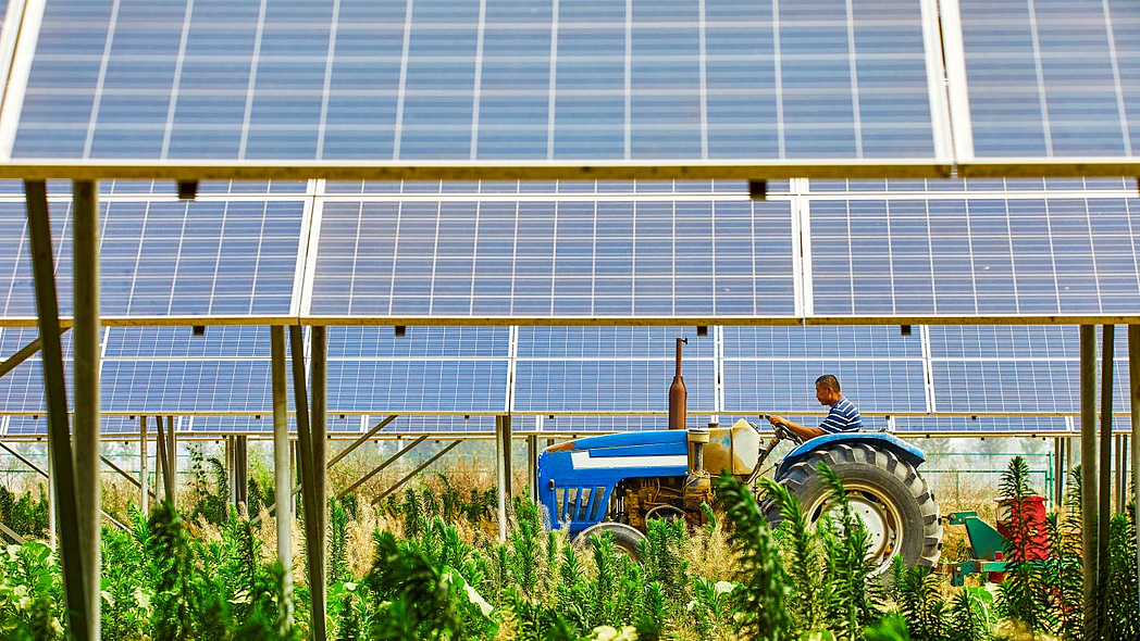 Traktor unter Solarmodulen
