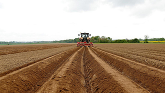 Traktor legt auf dem Acker eine Dammkultur an.