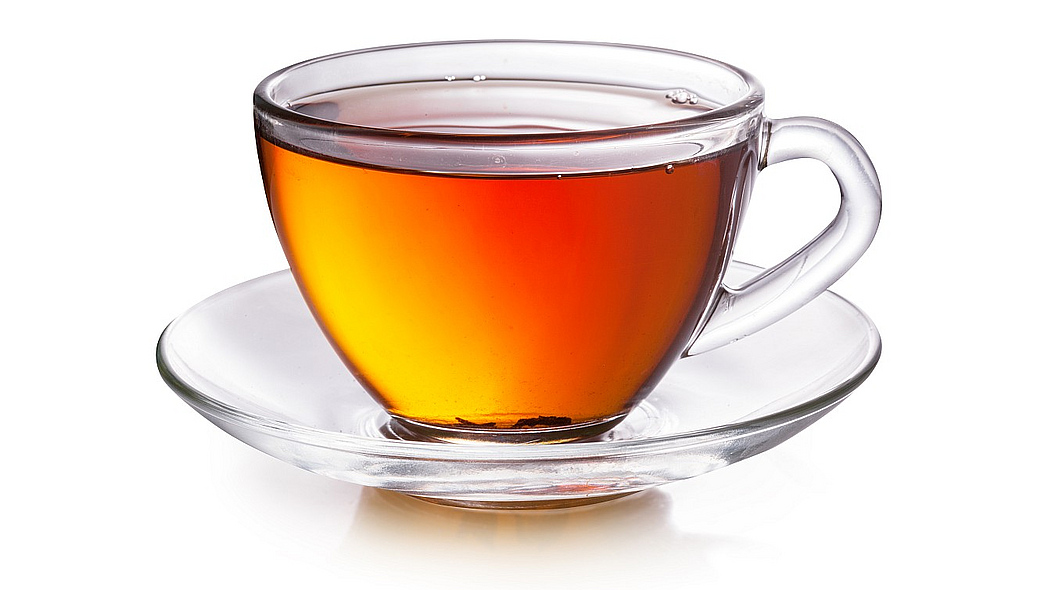 Eine gläserne Tasse mit schwarzem Tee.