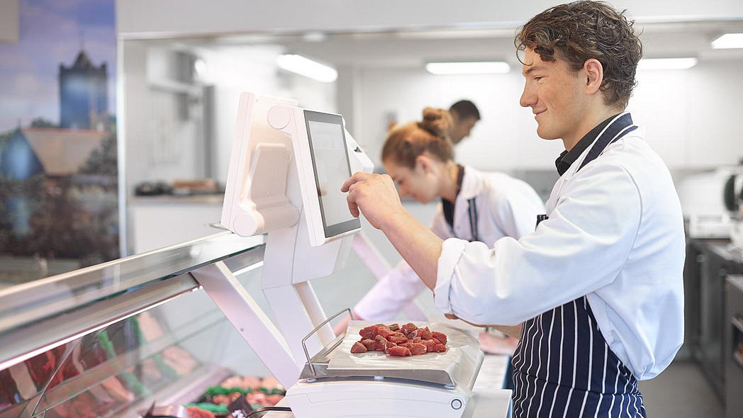 Ein Metzger wiegt Fleisch ab