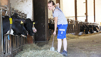 Eine Landwirtin in einem Kuhstall