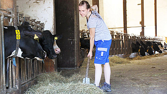 Eine Landwirtin in einem Kuhstall