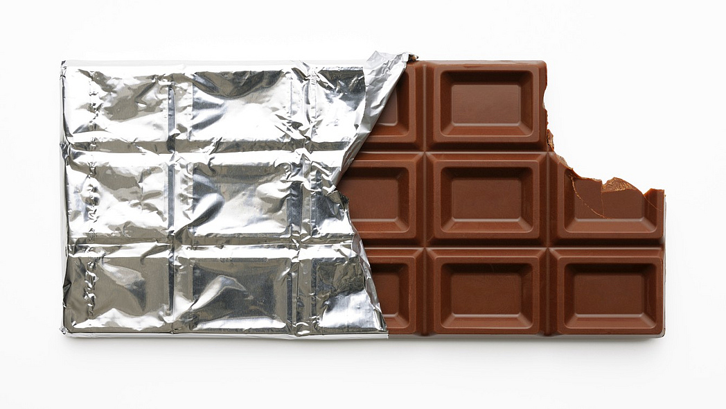 Eine halb ausgepackte, angebissene Tafel Schokolade.