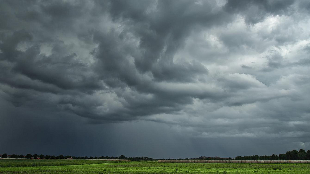 Dunkle Gewitterwolken über einem Acker