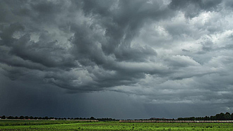 Dunkle Gewitterwolken über einem Acker