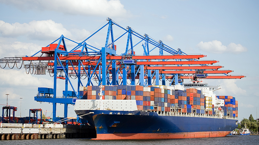 Ein Containerschiff liegt in einem Hafen.