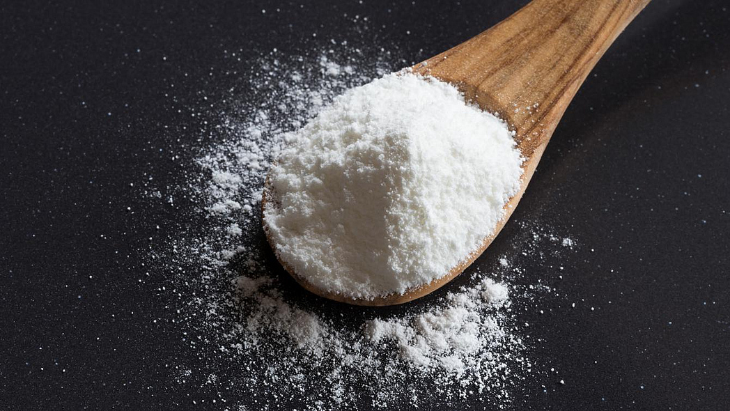 Holzlöffel mit Natron auf einem Tisch.