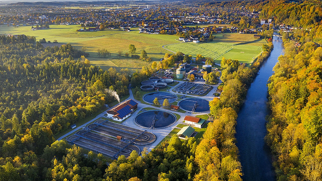 Luftaufnahme einer Kläranlage an einem Fluss.