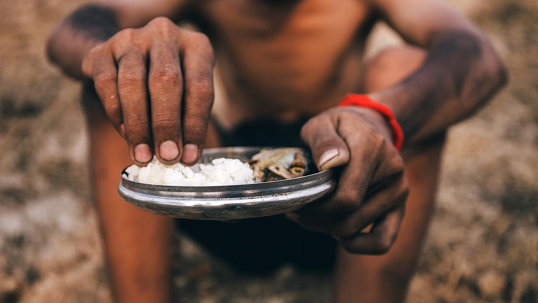 Un niño africano sostiene un plato de arroz.