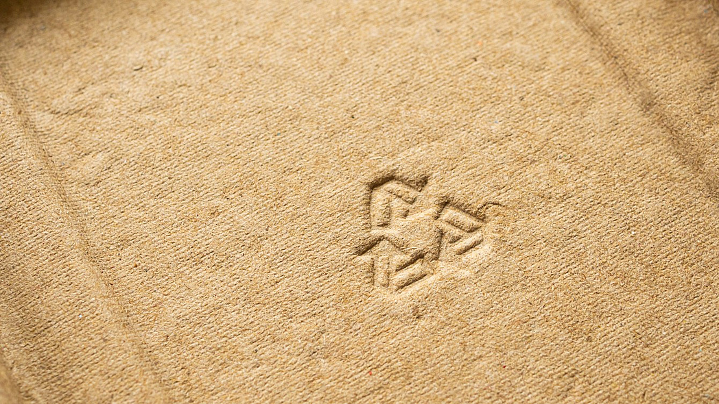 Ein Recyclingzeichen auf braunem Karton