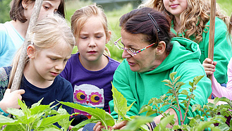 Eine Landwirtin im Gespräch mit Kindern