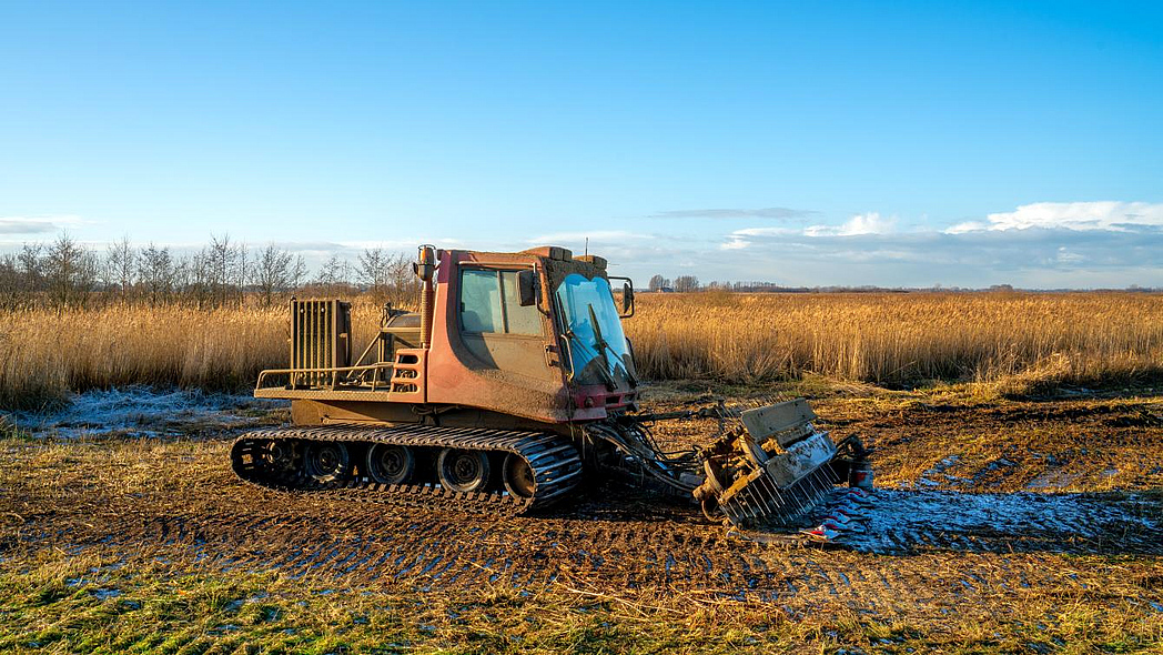 Raupenfahrzeug, ein spezielle angepasste landwirtschaftliche Maschine, zum Mähen von Schilf auf Moorboden